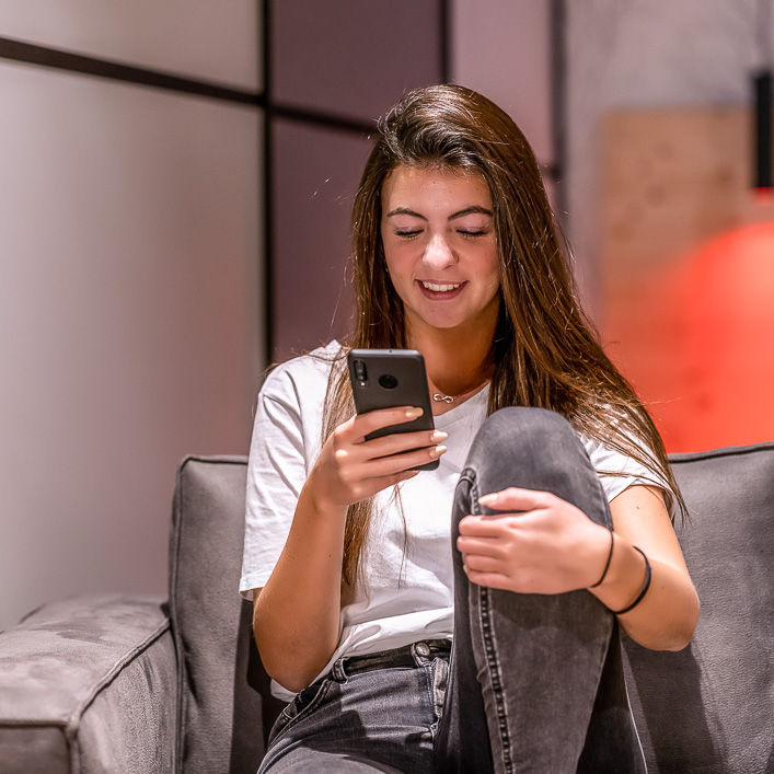 Frau blickt auf Smartphone in ihrer Hand