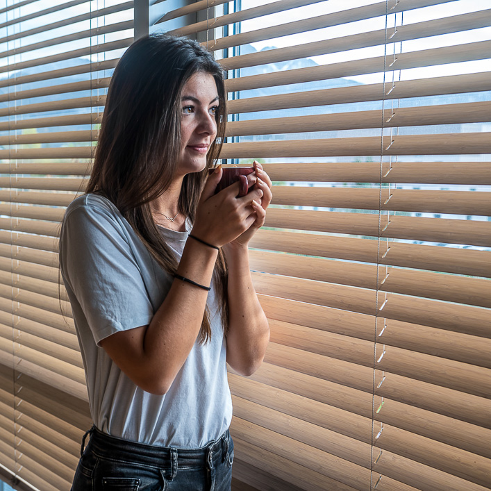 Frau vor Fenster mit Beschattung